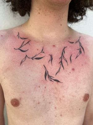 Striking blackwork leaf design on the chest by tattoo artist Jamie B.