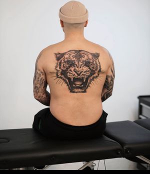 Bold blackwork tiger tattoo on the back, designed by Jamie B for a fierce and striking look.