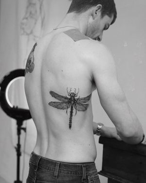 Unique blackwork dragonfly tattoo on ribs by artist Jamie B. Intricate design that symbolizes transformation and adaptability.