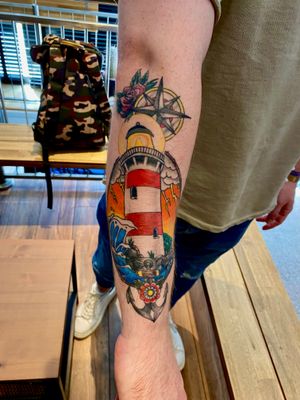 Get inked by Frankie Brown with this unique forearm piece combining a classic anchor and iconic lighthouse design.