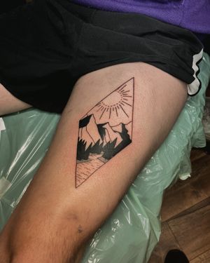 Discover the perfect blend of sun and mountain motifs in this stunning upper leg tattoo by Frankie Brown. Embrace the beauty of nature and precision of geometric lines.