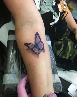 Adorn your forearm with a colorful butterfly design by renowned artist Frankie Brown. A unique twist on a timeless motif.
