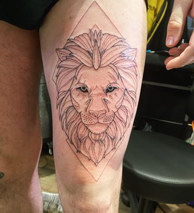 Adorn your upper leg with a sleek fine line geometric lion design, expertly crafted by tattoo artist Frankie Brown.