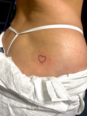 Elegant heart motif tattoo by Frankie Brown, delicately inked on the thigh for a subtle and stylish look.