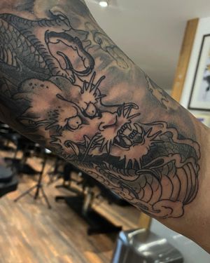 Experience the power and beauty of a black and gray Japanese dragon tattoo by artist Frankie Brown.
