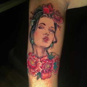 Beautiful neo traditional tattoo of a girl surrounded by flowers on the upper arm, created by artist Frankie Brown.