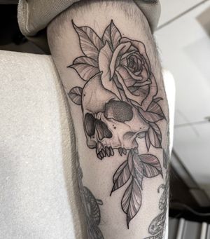 Exquisite black and gray tattoo by Federico Colantoni featuring a delicate flower intertwined with a menacing skull design.