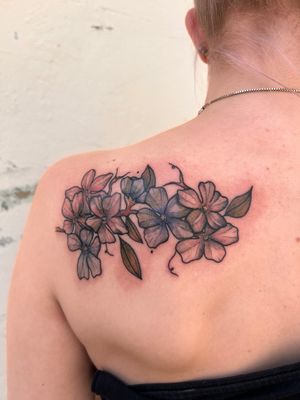 Adorn your upper back with a stunning floral masterpiece by Kiky Flore. Vibrant colors and delicate strokes create a dreamy watercolor effect.