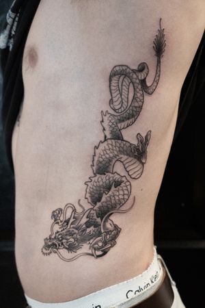 Elegant black & gray dragon tattoo inspired by Japanese art, expertly done by Luca Salzano on the ribs.