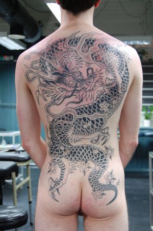 Experience the power of a traditional Japanese dragon in this stunning back piece tattoo by Bananajims. Intricate details and vibrant colors bring this mythical creature to life.