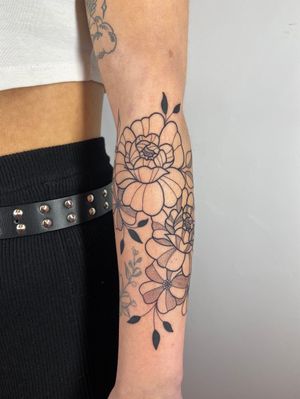 Exquisite peony and leaf design by Joanna Webb, creating a delicate and elegant look on your forearm.