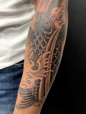 Elegant blackwork forearm tattoo by Kiko Lopes featuring traditional Japanese motifs of fish and waves.