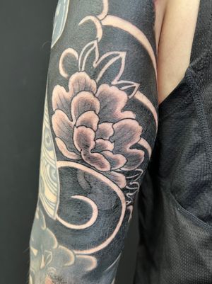Elegant blackwork floral design by Kiko Lopes, bringing traditional Japanese art to life on the upper arm.