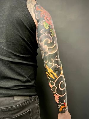 Elegant sleeve tattoo by Kiko Lopes featuring traditional Japanese clouds and delicate flower motifs.