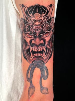 Immerse yourself in the ancient art of Japanese blackwork with this stunning upper arm tattoo featuring a fierce dragon and haunting hannya mask by Kiko Lopes.
