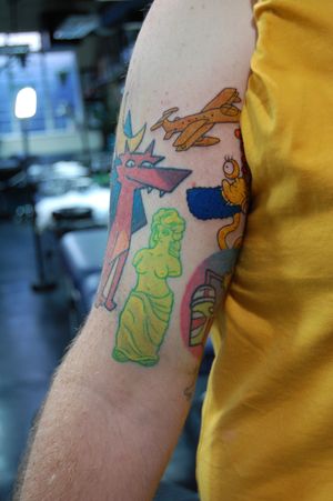 Vibrant new school anime style upper arm tattoo showcasing a unique statue motif by talented artist Bananajims.