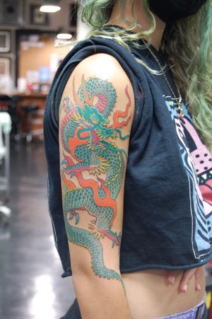 Get a stunning Japanese dragon tattoo on your upper arm by renowned artist Bananajims. Embrace the powerful and mystical symbolism of this ancient creature.