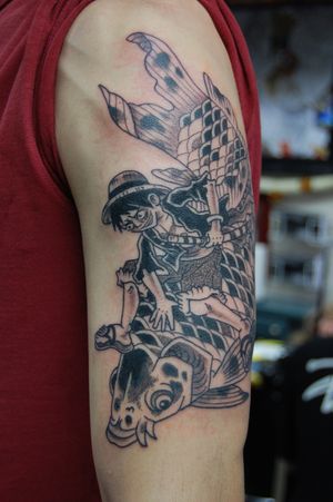 Get a vibrant and detailed anime tattoo featuring Luffy from One Piece on your upper arm by the talented artist Bananajims. Stand out with this unique piece of art!
