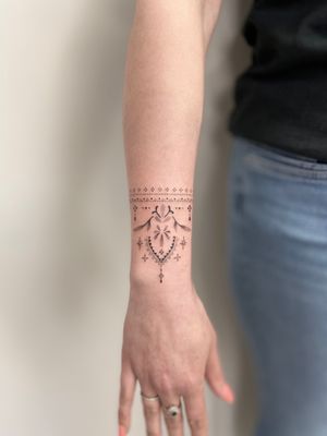 Elegant ornamental pattern tattoo by Viví Bogdanov, perfect for your forearm.