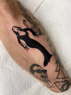 Elegant portrayal of Morticia by Miss Vampira. Bold blackwork design on the shin, exuding mystery and style.