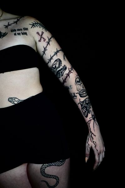 Get a mysterious and striking blackwork sleeve tattoo featuring a dino and moth by the talented artist Miss Vampira.