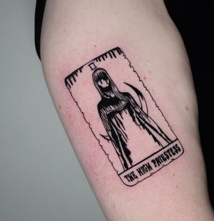 Elegantly inked on the upper arm, this blackwork tattoo featuring a delicate card motif and inspiring quote by Miss Vampira.
