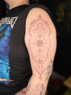 Elegant dotwork mandala tattoo on upper arm by Viví Bogdanov, featuring intricate ornamental patterns.