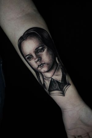 Stunning black & gray portrait of Wednesday Addams on forearm by tattoo artist Miss Vampira. A hauntingly beautiful piece.