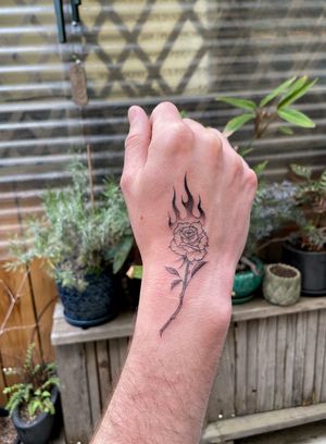 Flaming rose hand tattoo