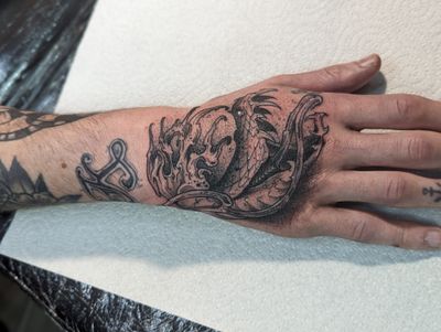 A unique combination of sea elements and a snake in black and gray traditional style by artist George Antony.