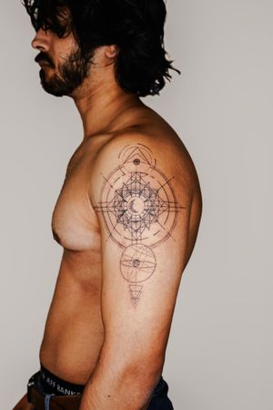 Get a stunning fine line geometric pattern tattoo on your upper arm by artist Gabriele Edu for a bold and unique look.
