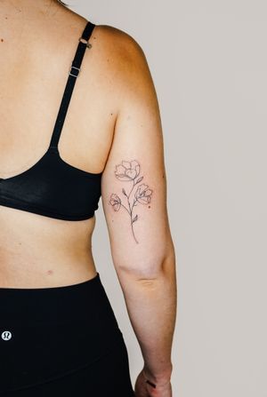 Beautiful flower and plant design by Gabriele Edu, perfect for a delicate and elegant look on your upper arm.