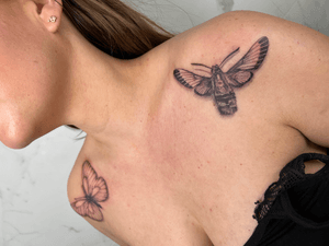 Experience the beauty of nature with this intricate blackwork tattoo featuring a butterfly and moth design on the shoulder.