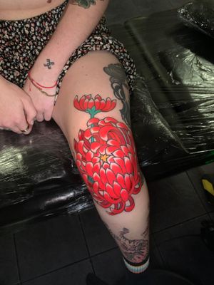 Beautiful chrysanthemum flower tattoo on upper leg by Andrea Furci, blending traditional and modern styles.