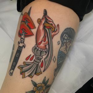 Get a classic traditional tattoo of a dagger and hand on your upper leg by the talented artist Andrea Furci.