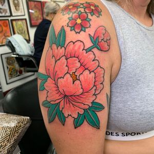 Beautiful neo traditional peony flower tattoo on upper arm by artist Andrea Furci. Vibrant colors and intricate linework.