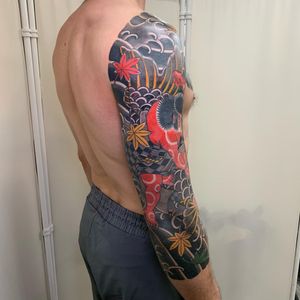 Impressive sleeve tattoo featuring a fierce samurai and intricate leaf design, expertly done by Andrea Furci.
