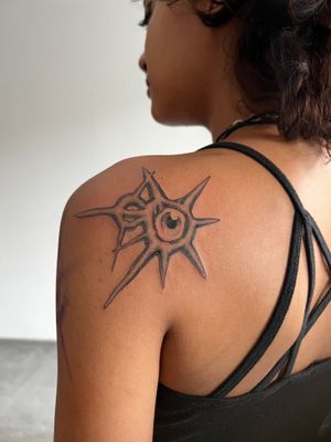 A stunning black and gray eye tattoo by Misa, beautifully placed on the upper back.
