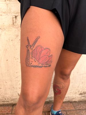 Adorn your upper leg with a delicate snail design by Kiky Flore, combining fine line and neo-traditional styles.