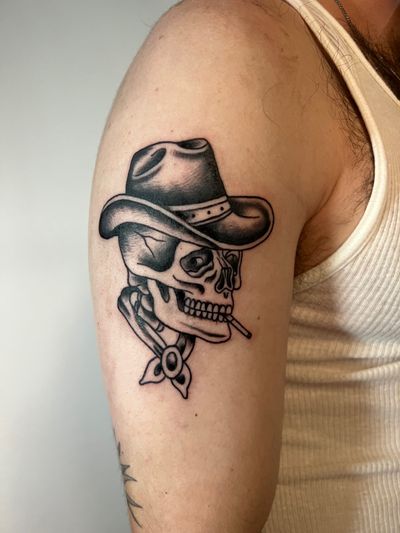 Get a badass traditional blackwork tattoo of a cowboy skull on your upper arm by Kayleigh Cole. Yeehaw!