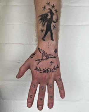Elegant and delicate fine line tattoo featuring a bird and flower motif on the hand by Jack Henry Tattoo.