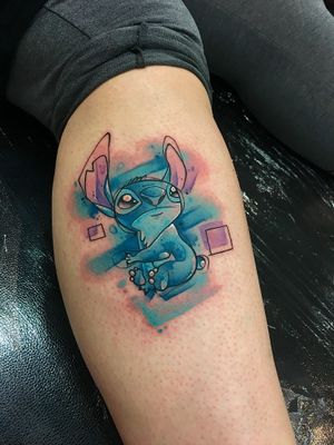 Get a unique and colorful anime new school style tattoo of a stitch motif on your shin by the talented artist Artemis.