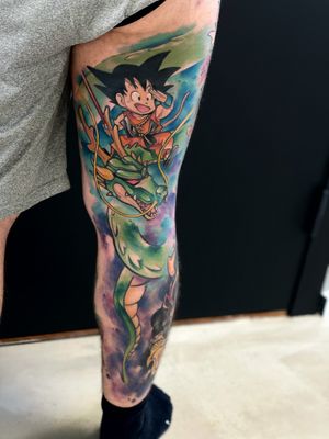 Get inked with a vibrant new-school anime tattoo featuring Goku and a fierce dragon on your upper leg by Artemis.