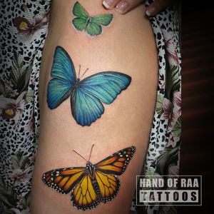 Vibrant and playful butterfly tattoo on the upper leg by artist Raa.