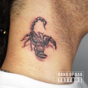 Get inked with a sleek black and gray scorpion design on your neck by the talented artist Raa. Stand out with this edgy and unique tattoo.