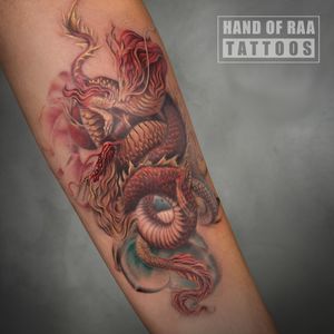 Immerse yourself in the mystique of traditional Japanese art with this intricate dragon design on the forearm by Raa.
