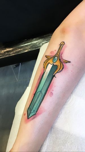 Get ready to wield your own anime-inspired sword with this colorful new school forearm tattoo by talented artist Artemis. Perfect for fans of Japanese animation and unique designs.