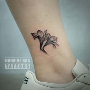 Beautiful black and gray flower tattoo on the ankle, done by the talented artist Raa.