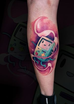 Get a vibrant new school tattoo of BMO from Artemis, perfect for anime fans. Show off your love for adventure time with this unique design.
