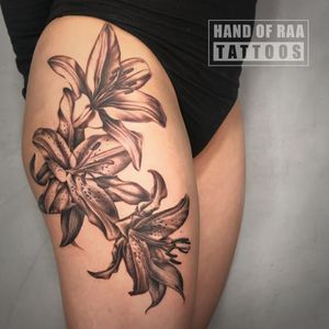 Elegant black and gray design of a flower on the upper leg by Raa.